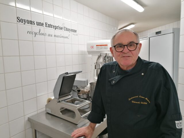 Gérard Caillé dans a cuisine avec sa devise au mur