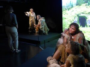 Une famille de Cro-Magnons decant un paysage qui évoque le Lascaux des origines