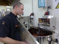 Du chocolat de la fève à la tablette Mathieu Robin devant in moulin où nait le chocolat après des heures de broyage