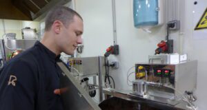 Du chocolat, de la fève à la tablette Mathieu Robin devant in moulin où nait le chocolat après des heures de broyage