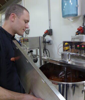 Du chocolat, de la fève à la tablette Mathieu Robin devant in moulin où nait le chocolat après des heures de broyage
