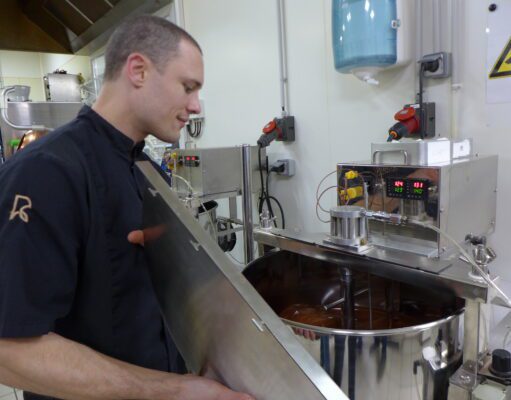 Du chocolat, de la fève à la tablette Mathieu Robin devant in moulin où nait le chocolat après des heures de broyage