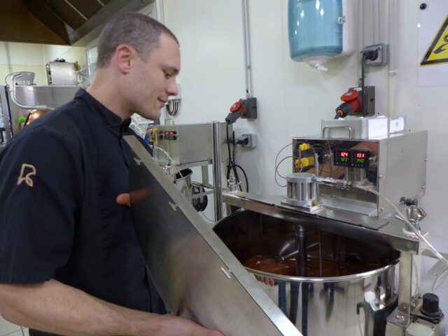 Mathieu Robin devant in moulin où nait le chocolat après des heures de broyage Mathieu Robin devant in moulin où nait le chocolat après des heures de broyage