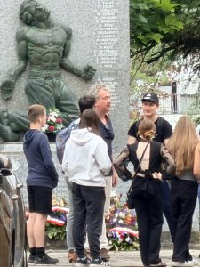 Patrice Rolli devant le monument rue Raoul Grassin à Mussidan avec des éléves de 3e